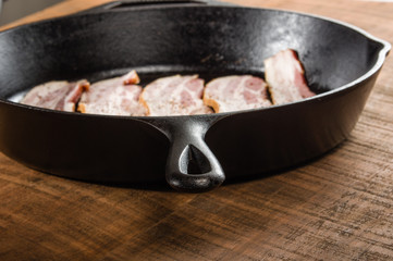 Black metal skillet or pan with bacon
