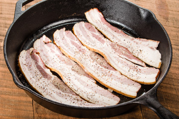 Metal frying pan with strips of bacon