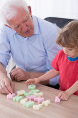 Grandfather teaching preschooler alphabet