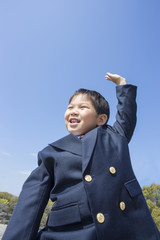 青空と手を上げる子供