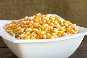 Golden corn grain in the bowl. Shallow depth of field.