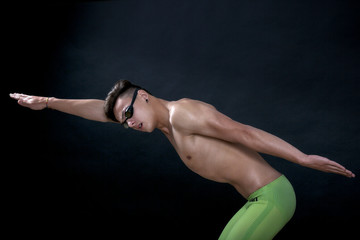 Fototapeta na wymiar Profile of young , caucasian athlete swimmer with goggles in sta