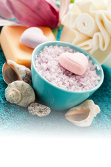 Spa setting with bath salt  and bath accessories on blue towel