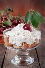 Tasty cherry dessert with milk cream in glass bowl 
