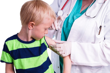 little boy is given an injection by the family doctor