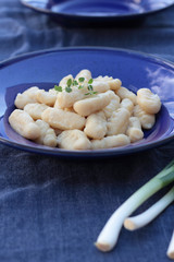 Gnocchi with oregano on a blue plate.