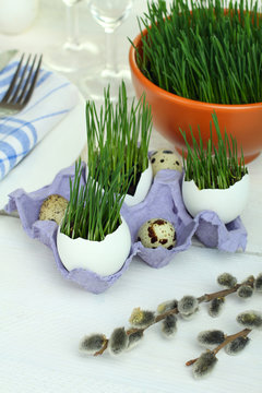 Green wheat sprouts in egg on a wooden background. Tableware