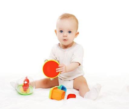 Portrait of baby sitting and playing with colorful toys