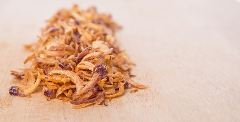 Deep fried shallots for garnishing on wooden surface