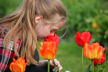 Obraz na płótnie Canvas girl smelling flowers in the garden 