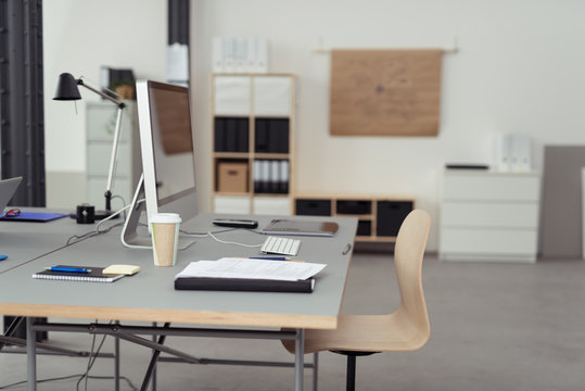 schreibtisch mit computer und unterlagen