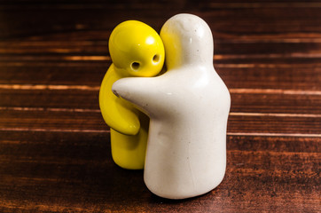 concept abstract of hugging ceramic dolls on wooden table