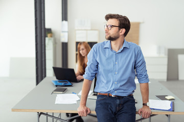 mann im büro schaut nachdenklich zur seite