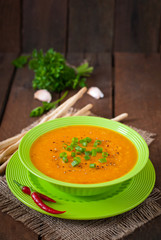 Delicious cream of pumpkin soup in green bowl 