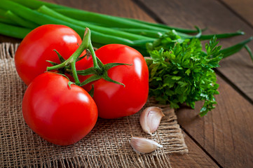 Branch of fresh tomato on wooden background