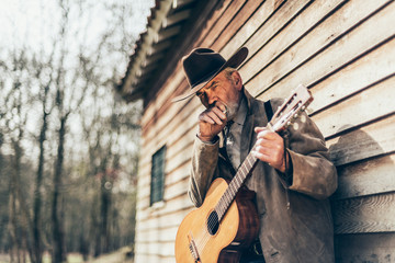Senior Country-Western Guitarist Leaning on a Wall