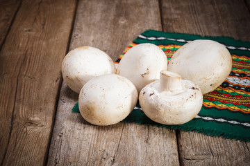 Fresh Organic mushrooms champignons on wooden background 