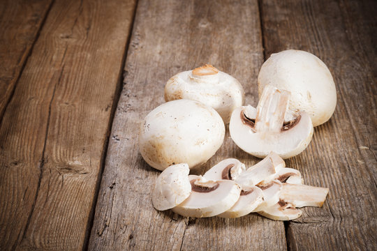 Fresh Organic mushrooms champignons on wooden background 
