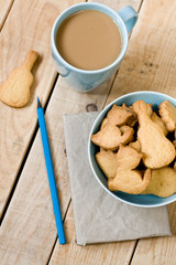Sweet tasty cookies in the blue plate, a cup of coffee with milk