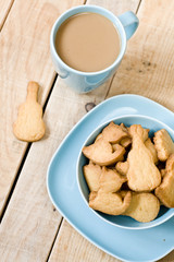 Sweet tasty cookies in the blue plate, a cup of coffee with milk