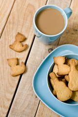 Sweet tasty cookies in the blue plate, a cup of coffee with milk
