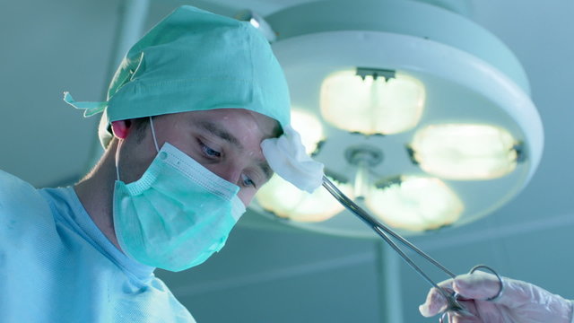 Wiping Sweat from Surgeon's Forehead