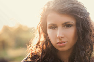Fototapeta premium Portrait of a beautiful young girl in the sunlight
