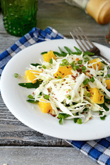  cabbage salad and orange on a white plate