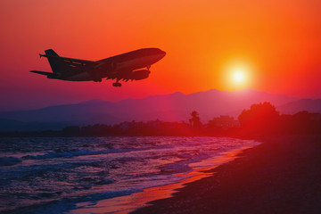 Airplane landing at sunset. Sea and Mountain background.