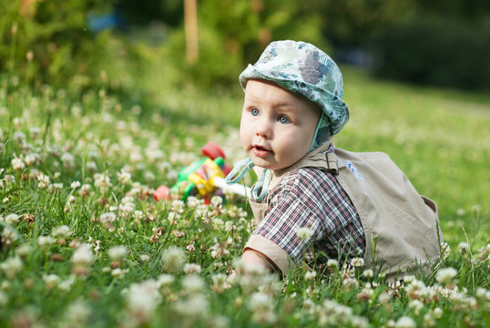 little blond kid playing on a summer meadow