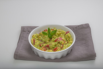 Aerial view closeup white bowl with spicy guacamole dip