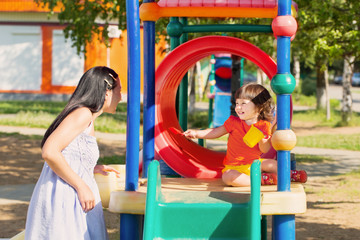 Fototapeta na wymiar Happy family on playground in summer