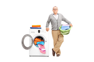 Senior holding posing next to a washing machine