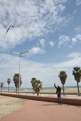Man flying a kite on the beach.