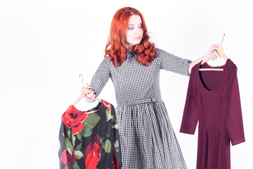 Beautiful woman does not know which dress to choose