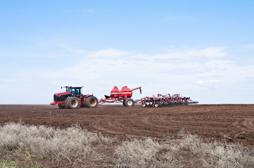 Fototapeta premium Traktor kołowy z siewnikiem