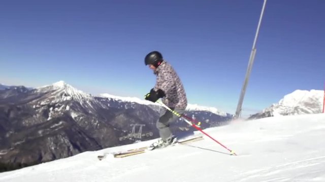 Slow Motion Of Skier Stopping And Spraying Snow On Slope With Mountain View