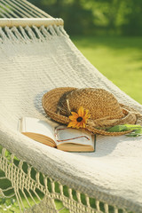 Straw hat and book on lace hammock - 82931864
