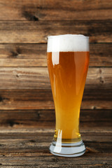 Glass of beer on a brown wooden background