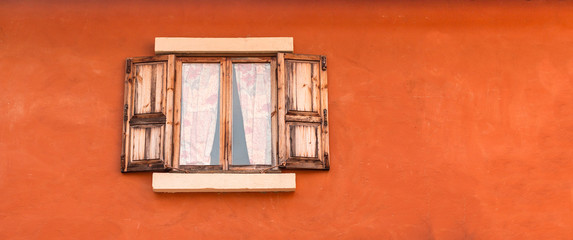 Vintage wooden window on orange cement wall can be used for back