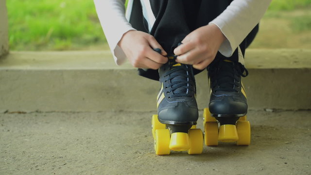 Woman Ties Roler Skates Shoe Laces