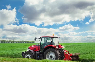 Poster Red tractor mows the grass. © vrstudio