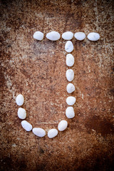 'J' alphabet made form white stone