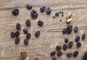 Coffe beans, cardamom and cinamon on wooden desk