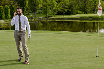 Businessman on phone while playing golf