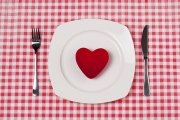 Red heart on plate on red gingham