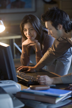 Asian businesspeople looking at computer