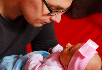 Father holding delicate his newborn baby.
