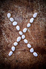'X' alphabet made form white stone