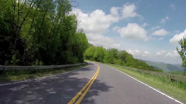 Car drives up an empty mountain road